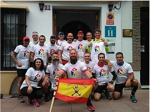 Equipo con camisetas blancas, reunidos sonrientes y listos para una actividad solidaria