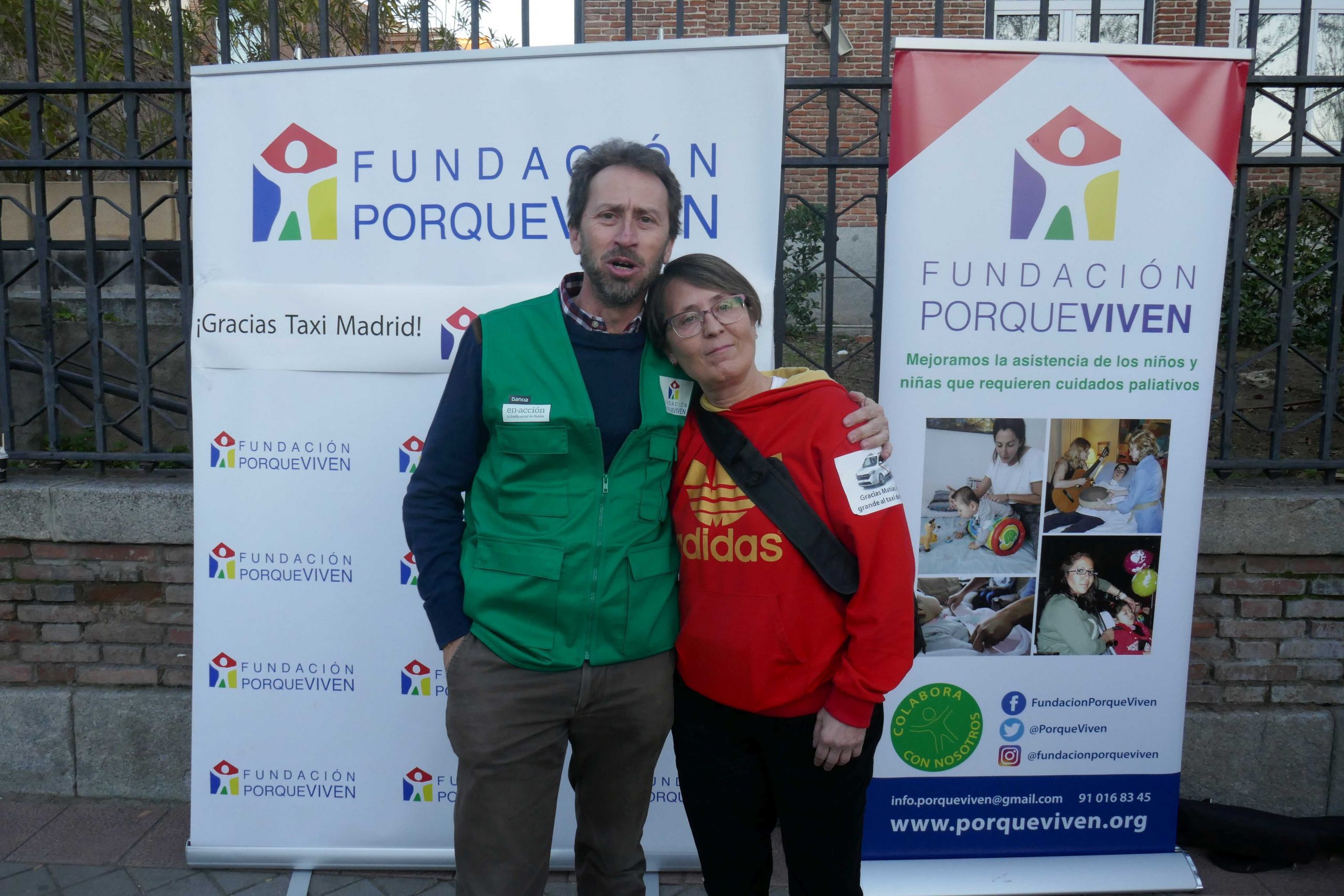 Dos personas, junto a lonas Fundación porqueViven, transmiten unión en un evento