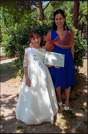 Una niña sonriente junto a una profesional de la , celebrando un logro