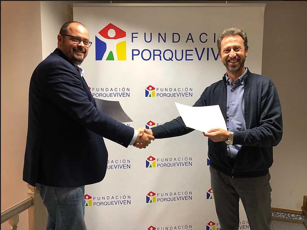Dos hombres se dan la mano y sonríen tras firmar un acuerdo de colaboración en cuidados paliativos pediátricos