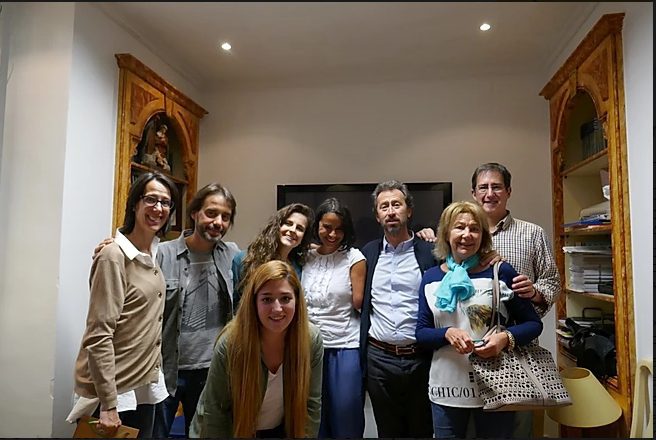 Ocho integrantes del equipo sonríen en una sala, con estanterías de libros al fondo, mostrando cercanía