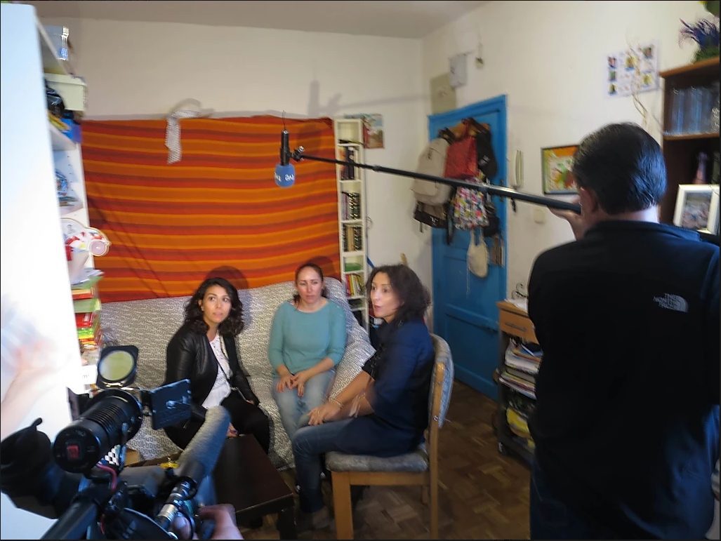 Tres mujeres conversan en una sala colorida y acogedora de la sede Fundación porqueViven, mientras un equipo graba su testimonio sobre