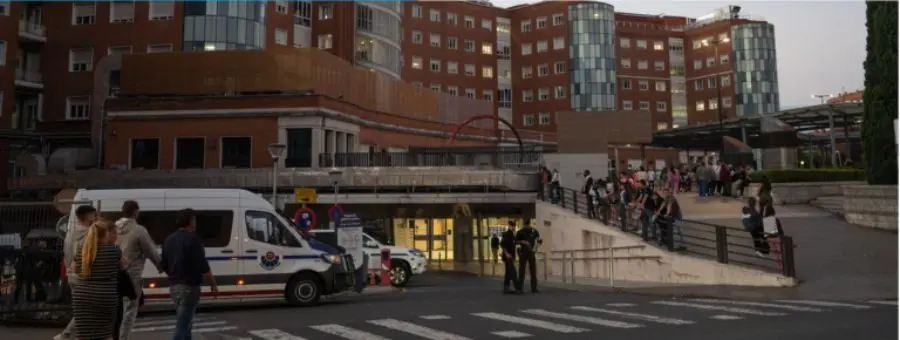 Al anochecer, varias personas y personal sanitario se reúnen junto a una ambulancia en la rampa de cuidados paliativos pediátricos del hospital en Madrid