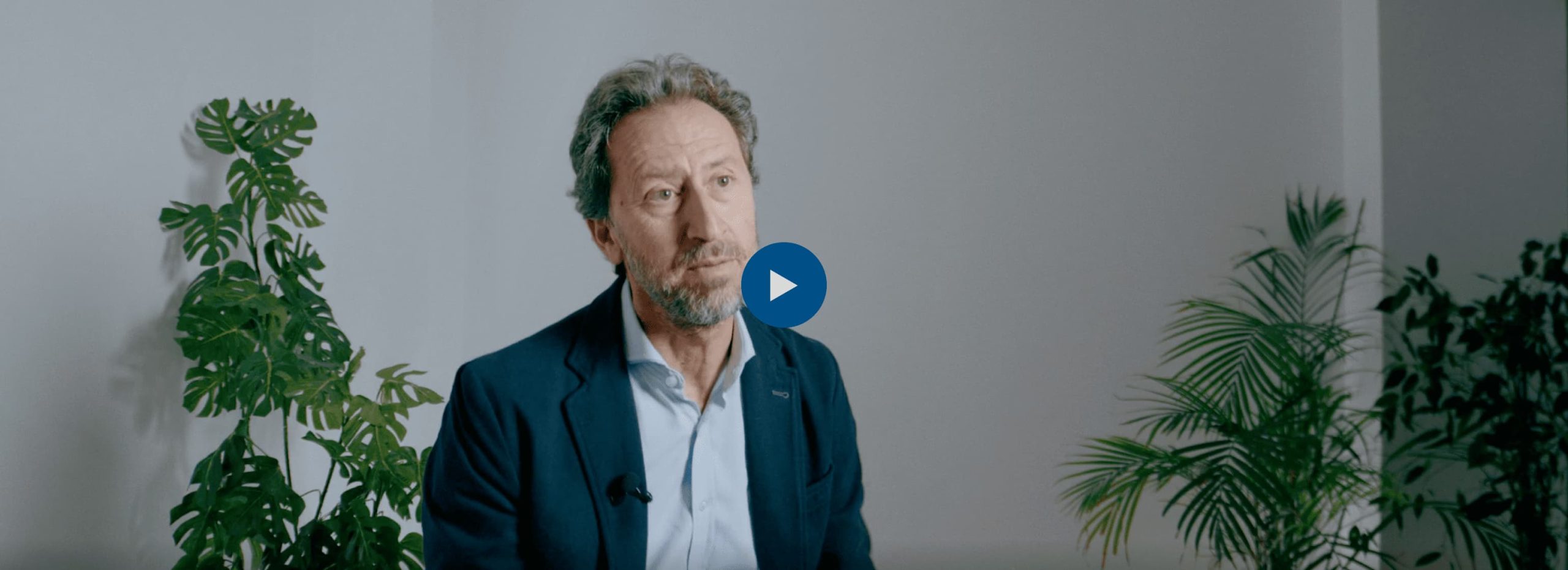 Un hombre de cabello canoso y barba, con chaqueta azul, participa en un video de la en Madrid