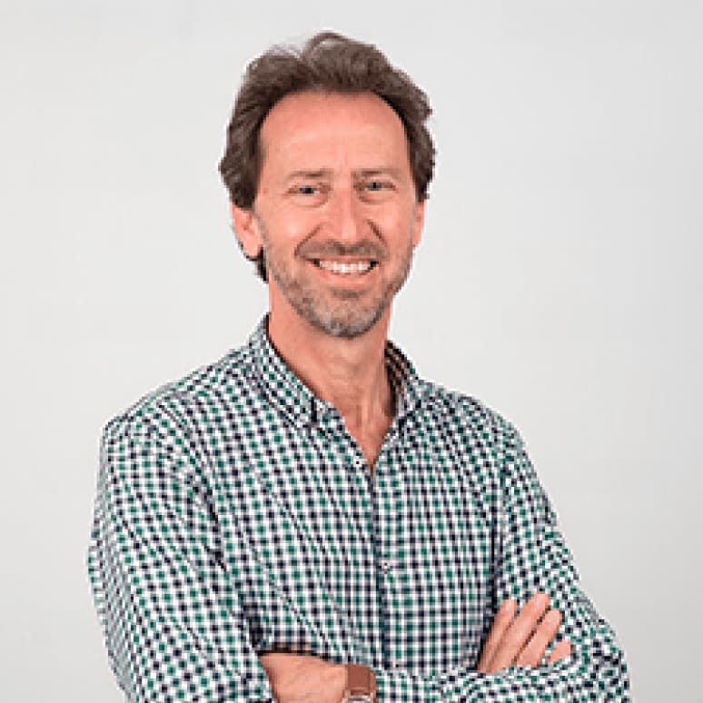Un hombre de cabello castaño y barba, sonriente y confiado, representa a en cuidados paliativos pediátricos