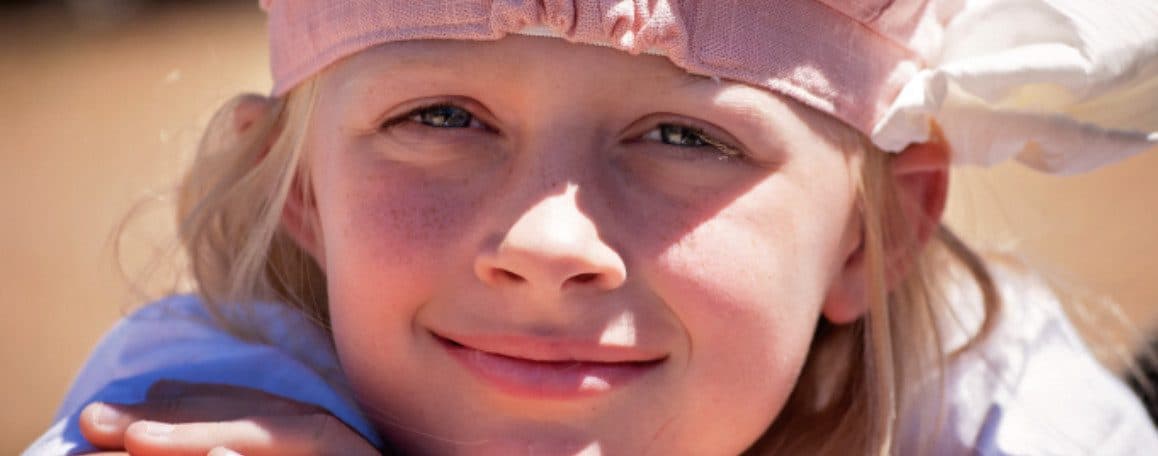Niña rubia con cinta rosa sonríe, reflejando la esperanza que aporta a los cuidados paliativos en Madrid