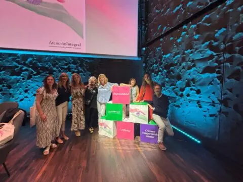 Ocho personas posan en un escenario junto a bloques coloreados Fundación porqueViven, promoviendo