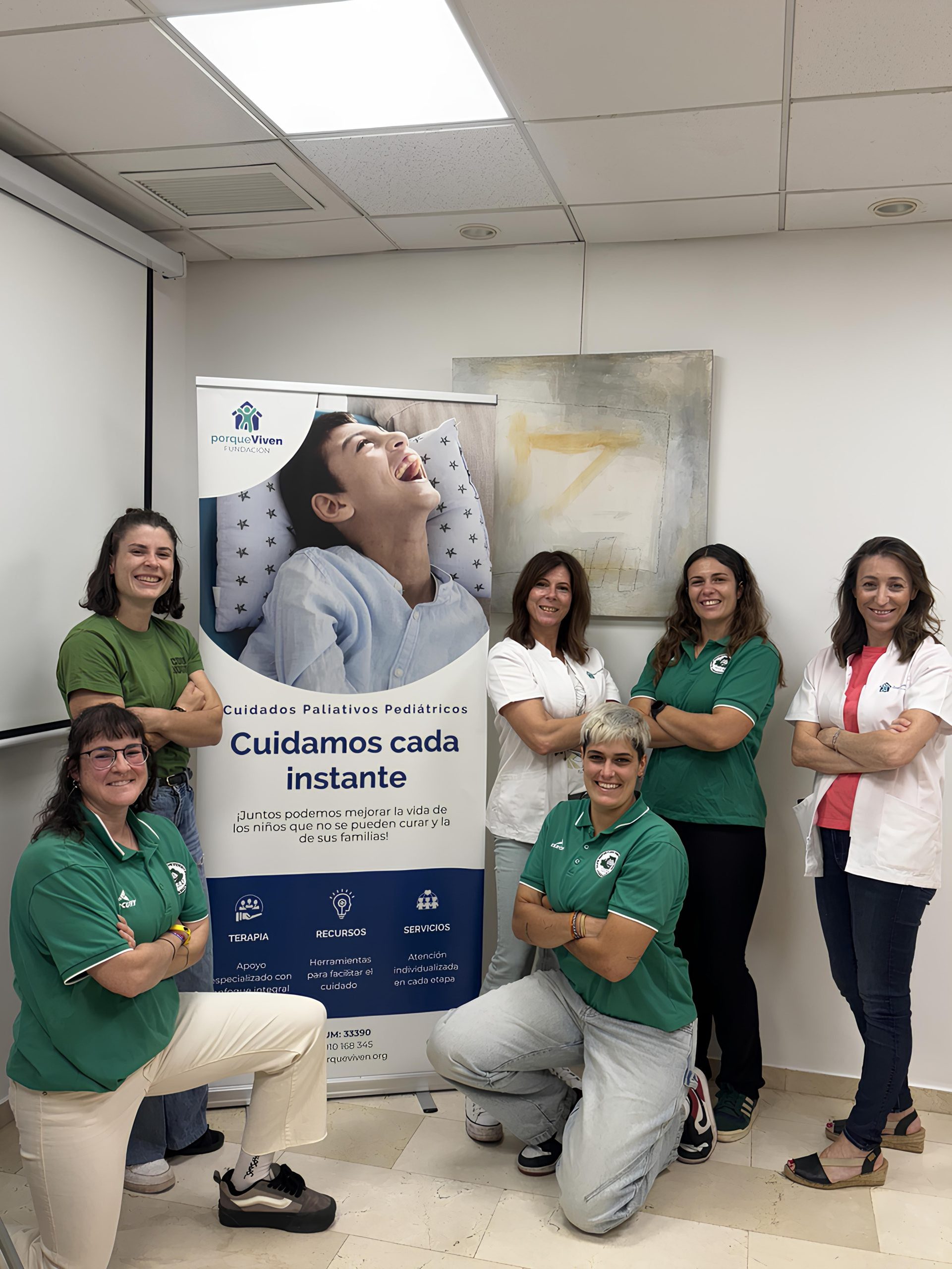 Seis mujeres de la posan sonrientes frente a un cartel sobre